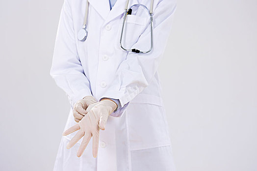 一位女医生戴上外科手套,特写
