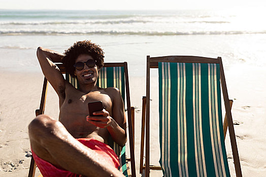 男人,打手机,放松,沙滩椅,海滩