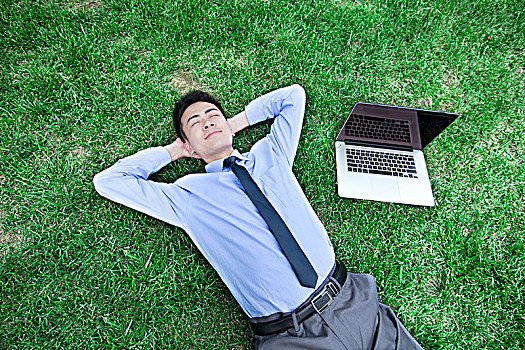 躺在草地上的商务男士