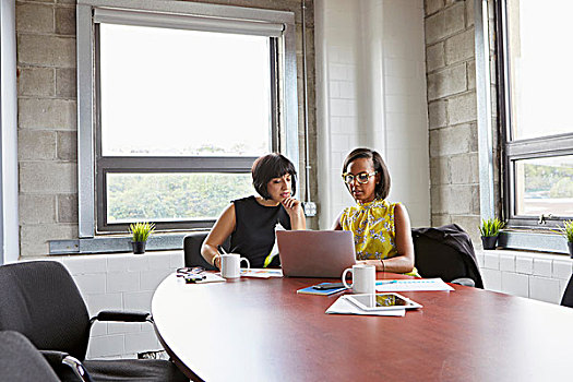 两个女人,坐,会议室,桌子,使用笔记本