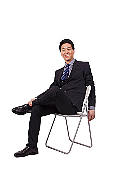 一个坐在白色折叠椅上的青年商务男士