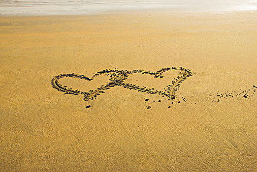 海边沙滩上两个交织在一起的心形图案