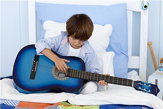 小男孩,弹吉他,床上