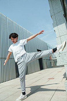 一名穿白色t恤的亚裔男子在屋顶户外健身运动
