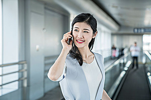 年轻商务女士在机场打电话