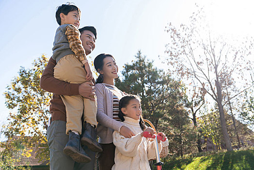 年轻夫妻带着孩子们在玩滑板车