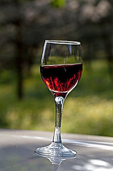 盛满红葡萄酒的透明玻璃高脚杯