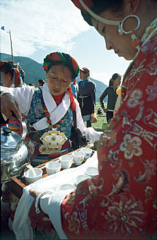 云南省迪庆州维西县塔城乡藏族赛马节上为骑手准备青稞酒的妇女