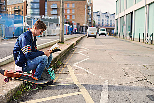 男青年,坐,路边,读,书本,滑板,旁侧,布里斯托尔,英国