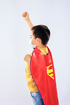 戴口罩的小男孩穿着超人披风