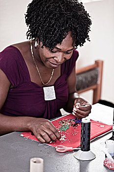 年轻的非洲妇女,做,珠饰细工,在书桌