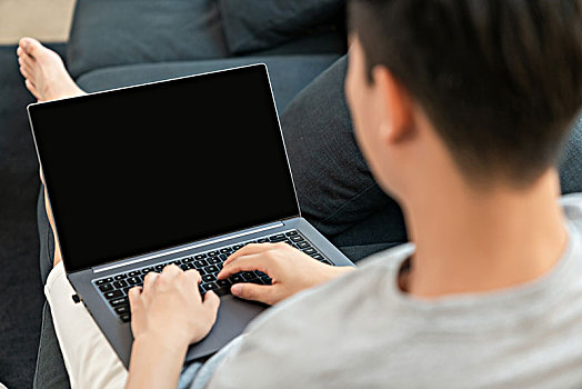 年轻男子在沙发上使用电脑