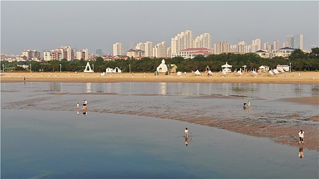 山东省日照市,雨后的海边环境宜人,游客赶海拾贝拍照打卡