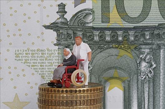男护士,推,老人,轮椅,雕塑,一堆,硬币,正面,钞票,象征,参与