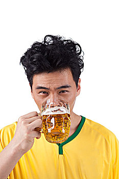 一个穿足球队服喝啤酒的男青年