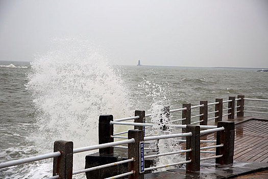 山东省日照市,灯塔风景区风大浪高,游客冒雨观赏浊浪排空奇观