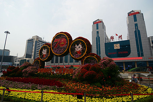 19年10月拍摄于河南省郑州火车站东广场,匆忙的行人,没有人的郑州站地标标志,和庆祝70年崛起新中原地区的园艺景观