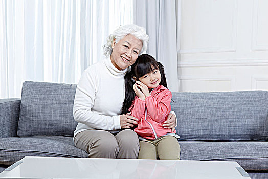 奶奶抱著孫女坐在沙發上