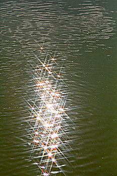 碧绿的湖水反射着阳光行程一片光斑