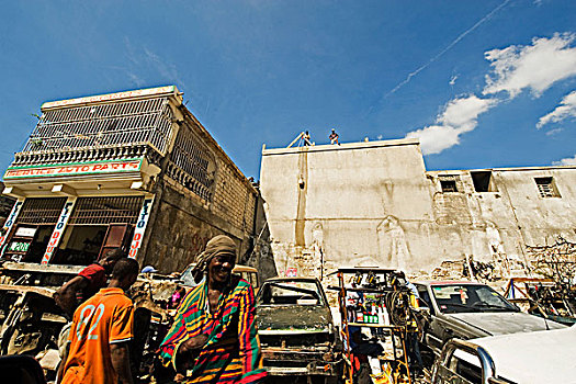 haiti,port,au,prince,smiling,black,man,in,front,of,building,reconstruction