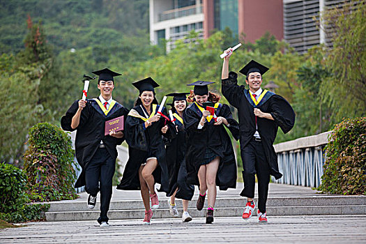 五个身穿学士服的大学生在校园奔跑