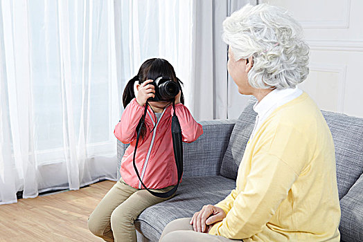 奶奶和孙女拿相机拍照