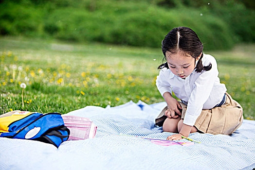 坐在草地上学习的小女孩