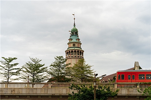 多云天户外拍摄驶过欧式建筑的轻轨电车