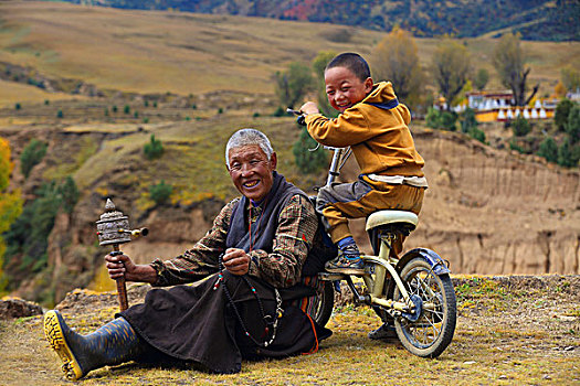 坐在草地上的西藏爷孙俩