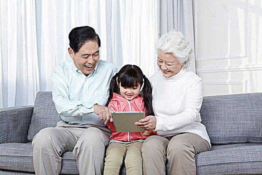 爷爷奶奶和孙女一起用平板电脑