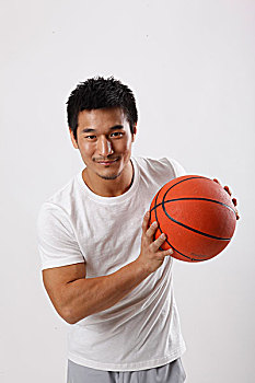 一个穿休闲装打篮球的青年男士