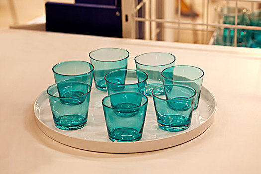 八个透明的蓝色玻璃杯放在一个圆盘中