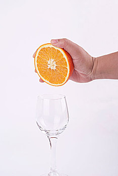 用手挤橙汁到玻璃杯里