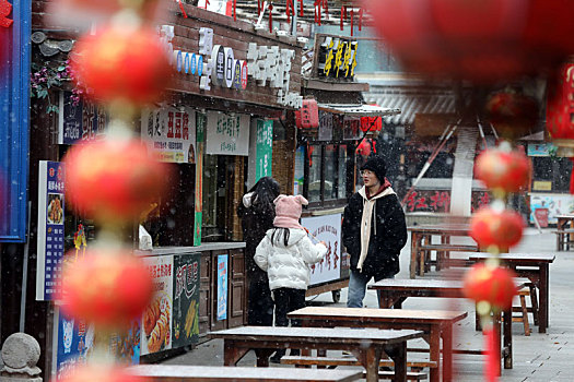 山东省日照市,小年迎来初雪,市民雪中漫步东夷小镇