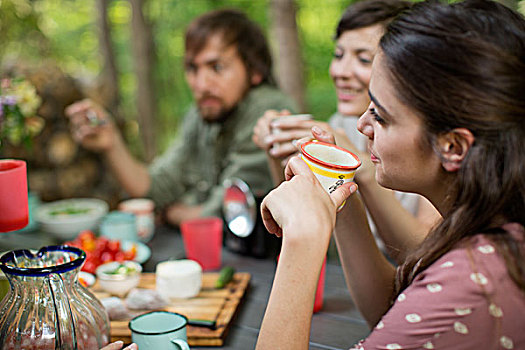 四个人,坐,木桌子,户外,树林,分享,食物