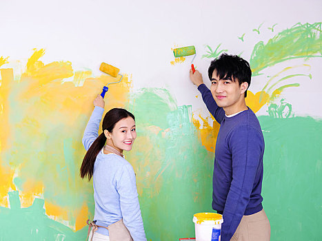 年轻情侣粉刷墙面