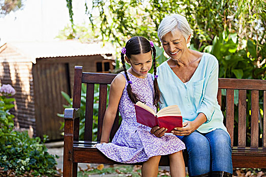微笑,祖母,读,书本,孙女,坐,木制长椅,后院