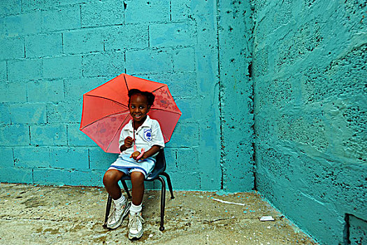 dominica,roseau,preschool,ccf,young,girl,playing,with,pink,umbrella,against,blue,wall