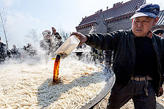 豫北农村厨师为大锅饭添加酱油调味品