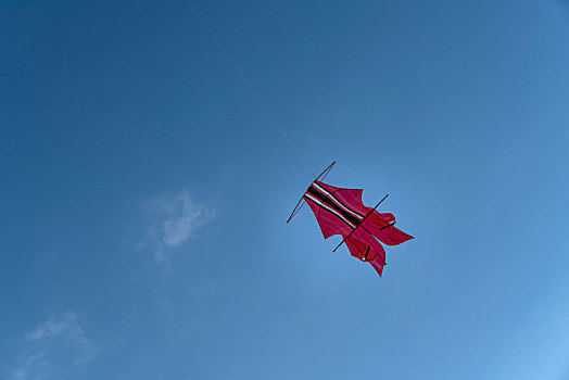 巴厘岛金巴兰海滩蓝天上的红色风筝