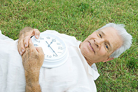 老人,躺着,草,拿着,钟表,看镜头,微笑