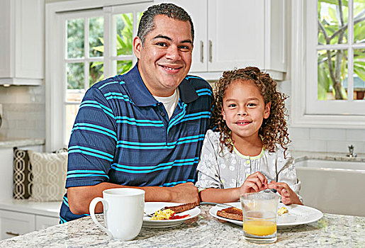 父亲,女儿,并排,厨房操作台,吃饭,早餐,看镜头,微笑