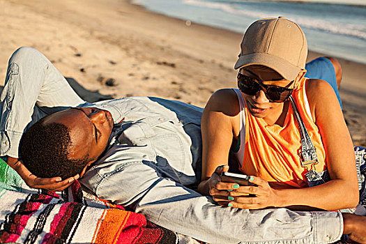 年轻,情侣,卧,一起,海滩,女人,看,智能手机