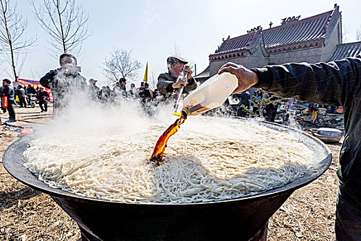 豫北农村厨师为大锅饭添加酱油调味品