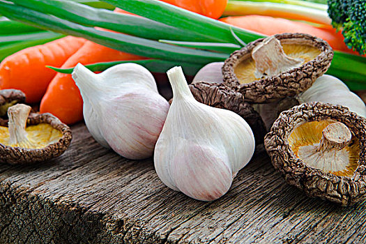 蒜與香菇,烹飪食很重要的調味料香料,香菇和蒜頭與多樣蔬菜,在原木桌上