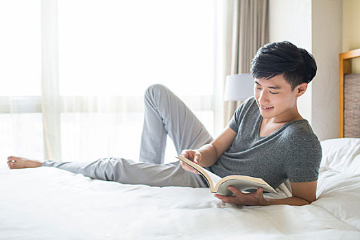 年轻男子在床上读书