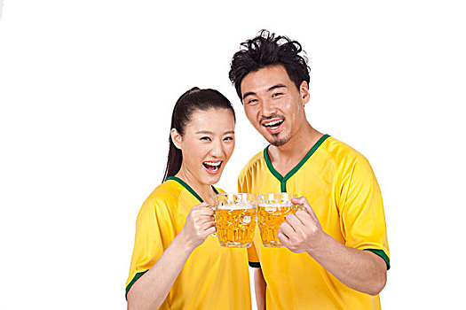 一对穿足球队服喝啤酒的青年情侣