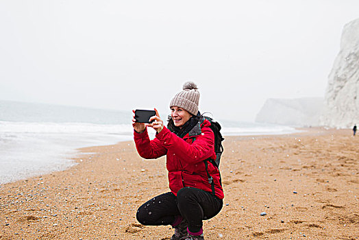 女人,厚衣服,拍照手机,雪,海滩