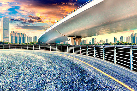 空旷无人的沥青路,立交桥与现代城市建筑日落景观