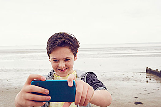 微笑,少男,智能手机,海边,海洋,艾塞克斯,英国